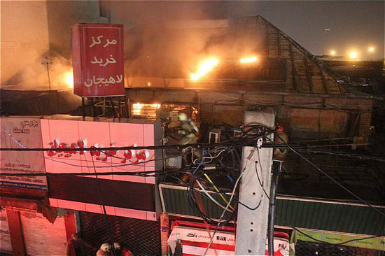 پاساژ لوازم خانگی شوش در آتش سوخت/ عملیات شبانه آتش نشانان برای نجات نگهبان+ تصاویر
