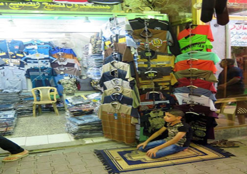 نماز اول وقت نوجوان کاسب جلوی مغازه + عکس