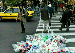 تردد در شهر با دست&zwnj; و پاهای زنجیر شده به بطری&zwnj;های پلاستیکی