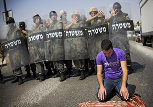 نماز خواندن یک جوان فلسطینی در میان تیراندازی صهیونیست‌ها + فیلم