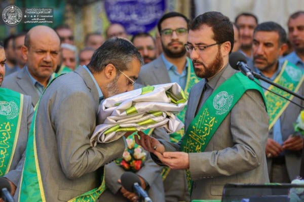 مراسم تعویض پرچم گنبد حرم امیر المؤمنین(ع) توسط خادمان+عکس