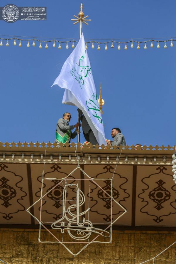 مراسم تعویض پرچم گنبد حرم امیر المؤمنین(ع) توسط خادمان+عکس