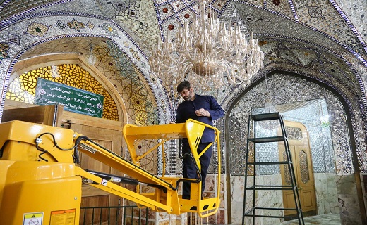 تلاش خادم افتخاری برای تنظیف ۵۵۰ لوستر حرم بانوی کرامت+تصاویر
