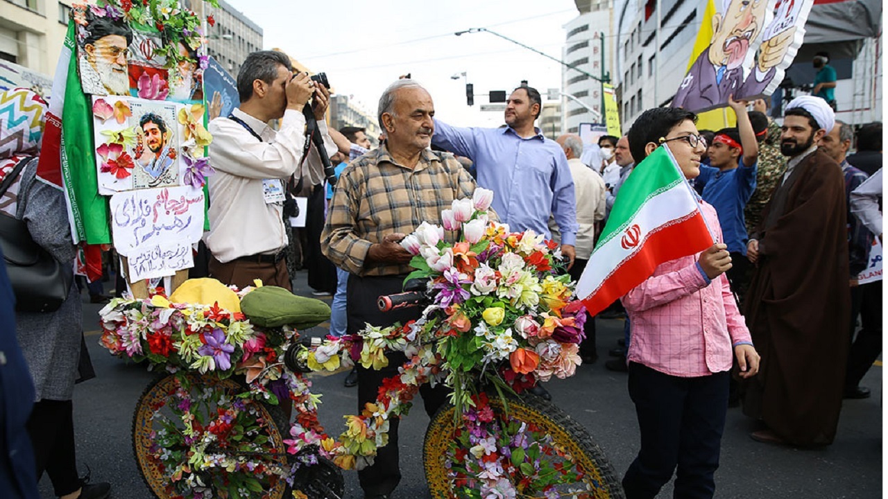 جوان نسل اول انقلاب با دوچرخه گل زده در راه پیمایی + فیلم
