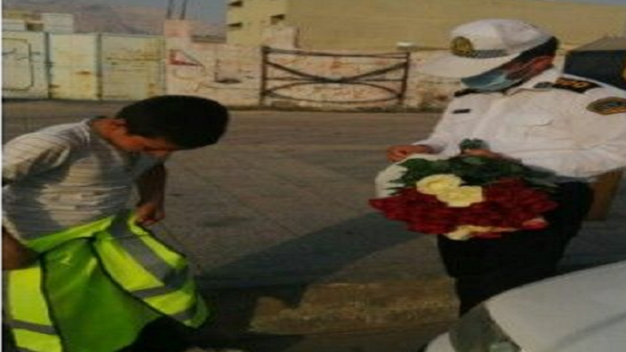 مامور پلیس کنگان جلیقه شب‌رنگش را بر تن کودک کار کرد