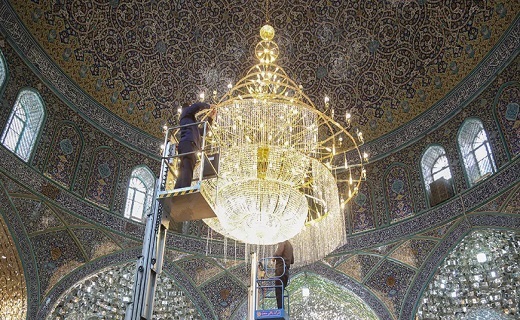 غبار روبی بزرگترین لوستر حرم حضرت معصومه(س) +تصاویر