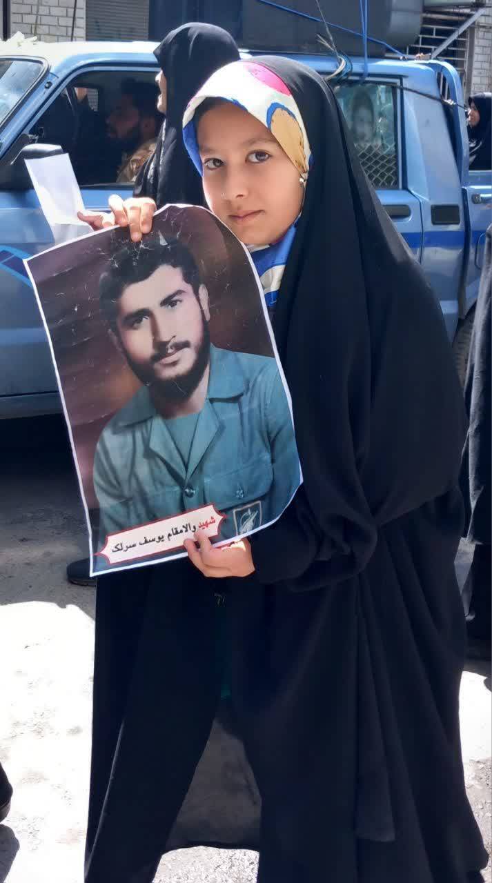 تصویر یادگاری دختری با عکس شهید سرلک