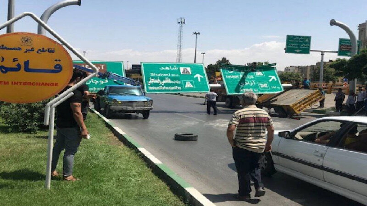 سقوط یک تابلوی تبلیغاتی روی ٢ خودرو جرثقیل در میدان قائم مشهد