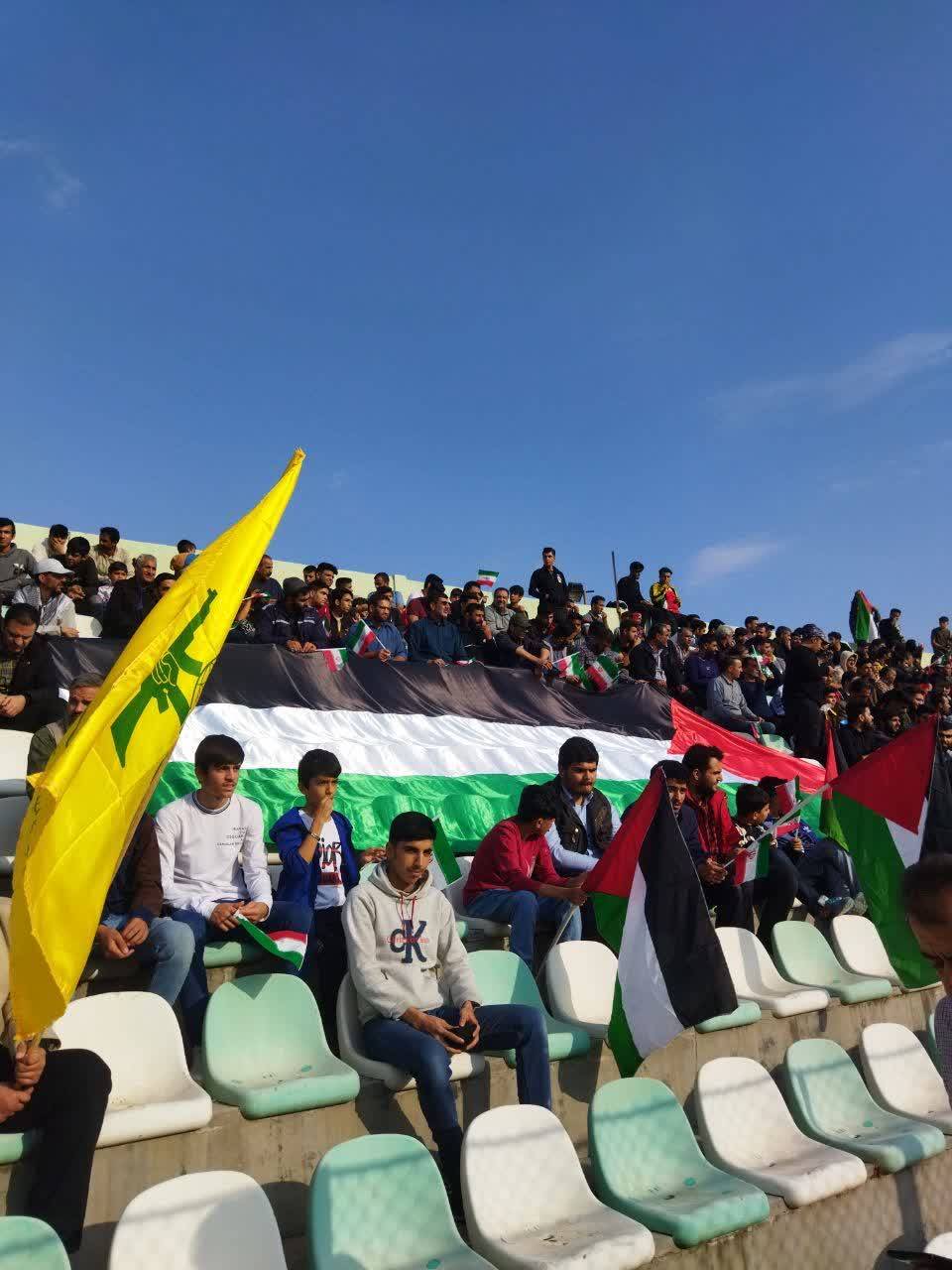تماشاچیان فوتبال با در دست داشتن پرچم فلسطین