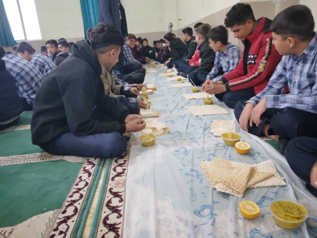دانش آموزان بر سر سفره نذری