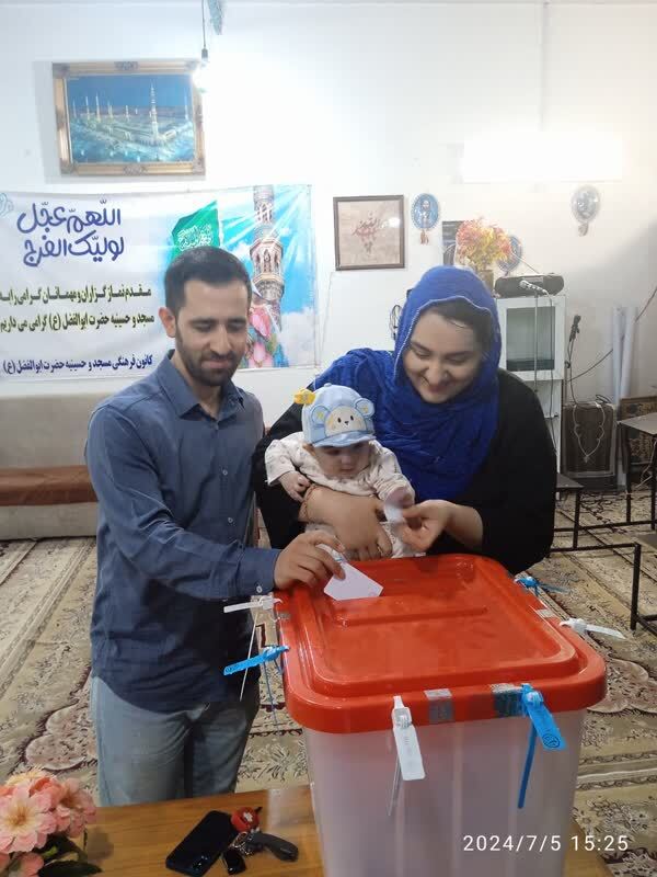 حضور کودکی به همراه والدین در پای صندوق رای