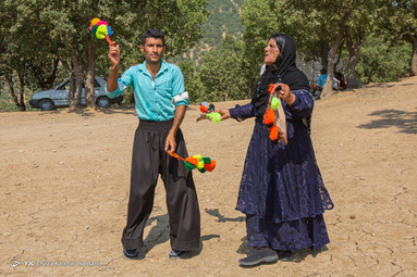 زن‌ها کل می‌کشند و در صف مرتب می‌ایستند، رنگ‌های تند و زیبا در زیر نور آفتاب می‌درخشند، لباس‌ها بلند و پوشیده و خوش رنگ روستا را فرا می‌گیرند دستمال‌ها در حرکت مواج تکان می‌خورند