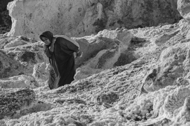 یکی از زنان در حال انتقال نمک که از صخره ها توسط تیشه کنده به پاببن صخره