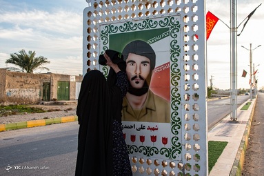 منیژه صحراگرد، مادر شهید علی احمدی هر روز اقدام به تمیز کردن تصویر پسر شهیداش که در خیابان نصب شده می‌کند - بوشهر