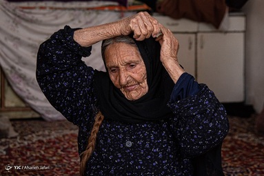 منیژه صحراگرد، مادر شهید علی احمدی هر روز اقدام به تمیز کردن تصویر پسر شهیداش که در خیابان نصب شده می‌کند - بوشهر