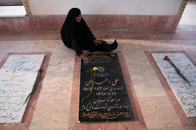 منیژه صحراگرد، مادر شهید علی احمدی هر روز اقدام به تمیز کردن تصویر پسر شهیداش که در خیابان نصب شده می‌کند - بوشهر