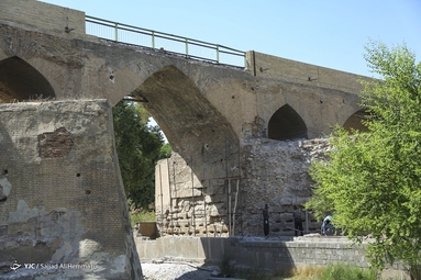 نمایی از بخش پایین پل دزفول که درحال مرمت غیراصولی است