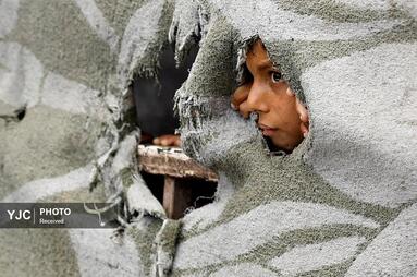 کودک فلسطینی در حال تماشای مراسم تشییع کودک فلسطینی که با گلوله تانک صهیونیست ها شهیدشد، غزه